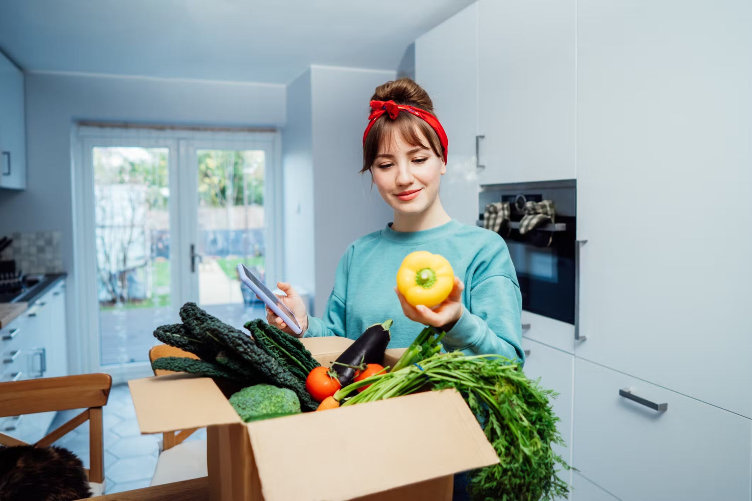 a woman in her kitchen looking a fresh produce delivered by goodfood2u